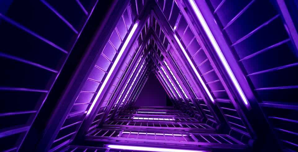 Triangular architecture with neon lighting with floor to sky perspective.